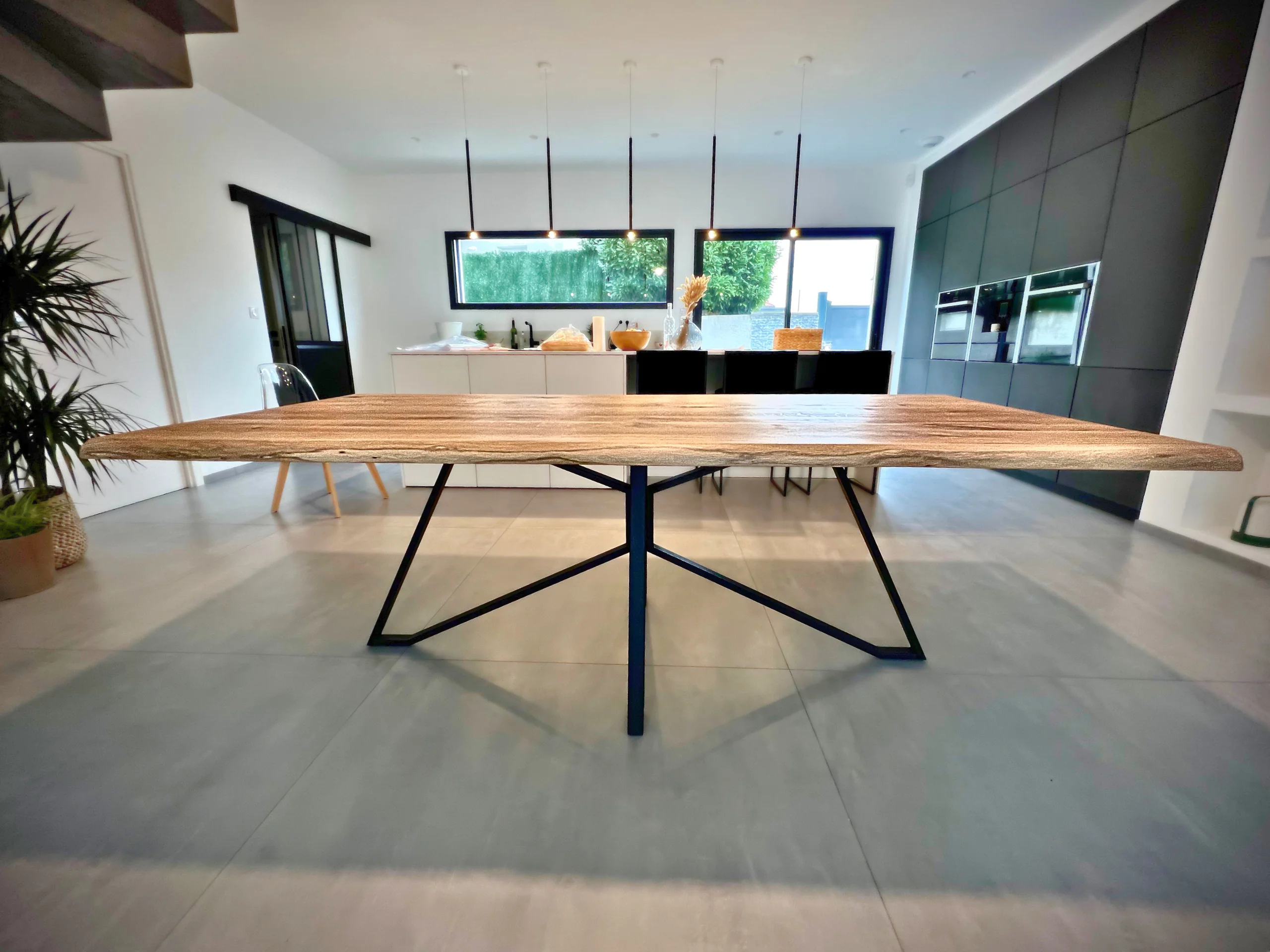 A dining table with a graphic Spider black steel base in a dining room