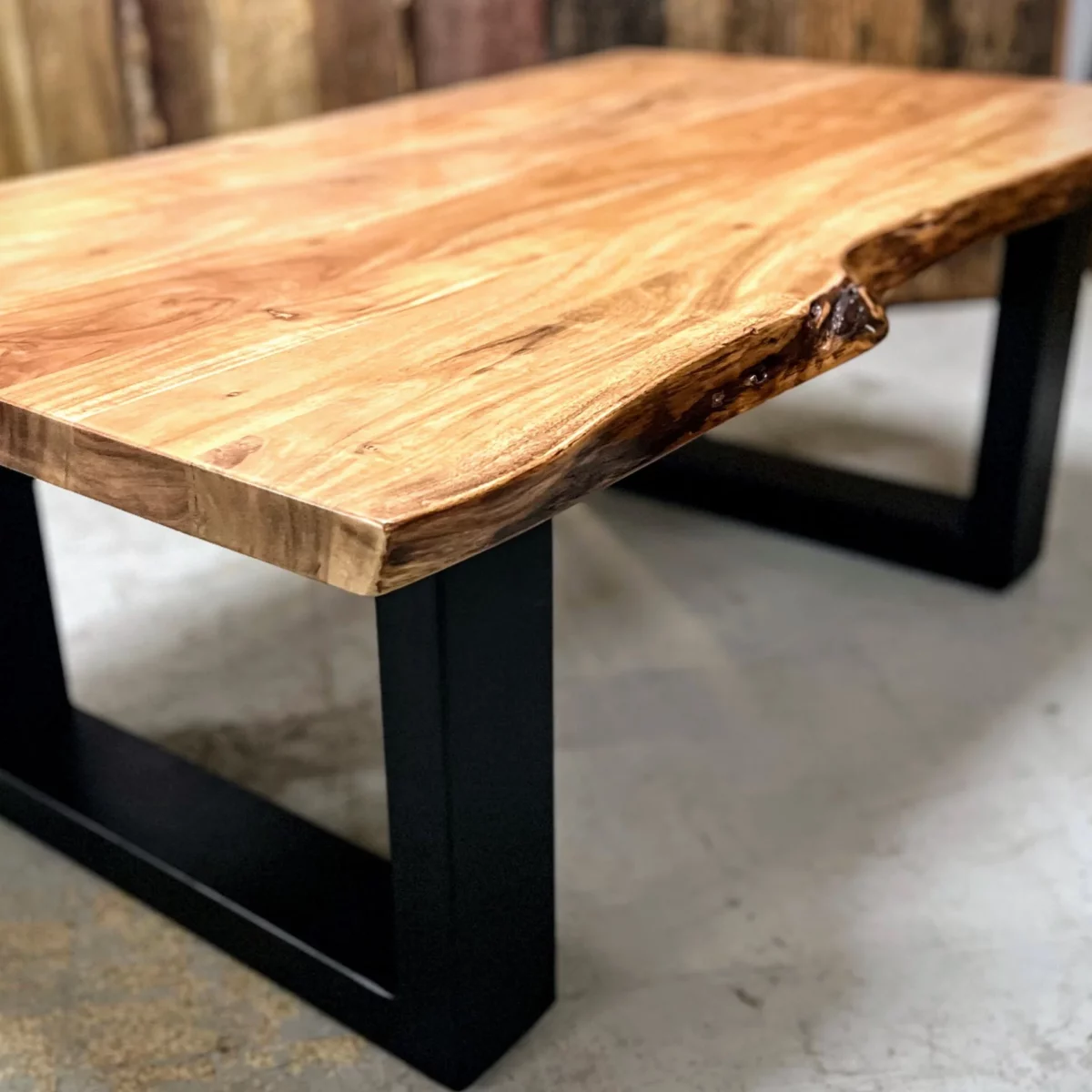 A solid wood coffee table with U-shaped steel legs