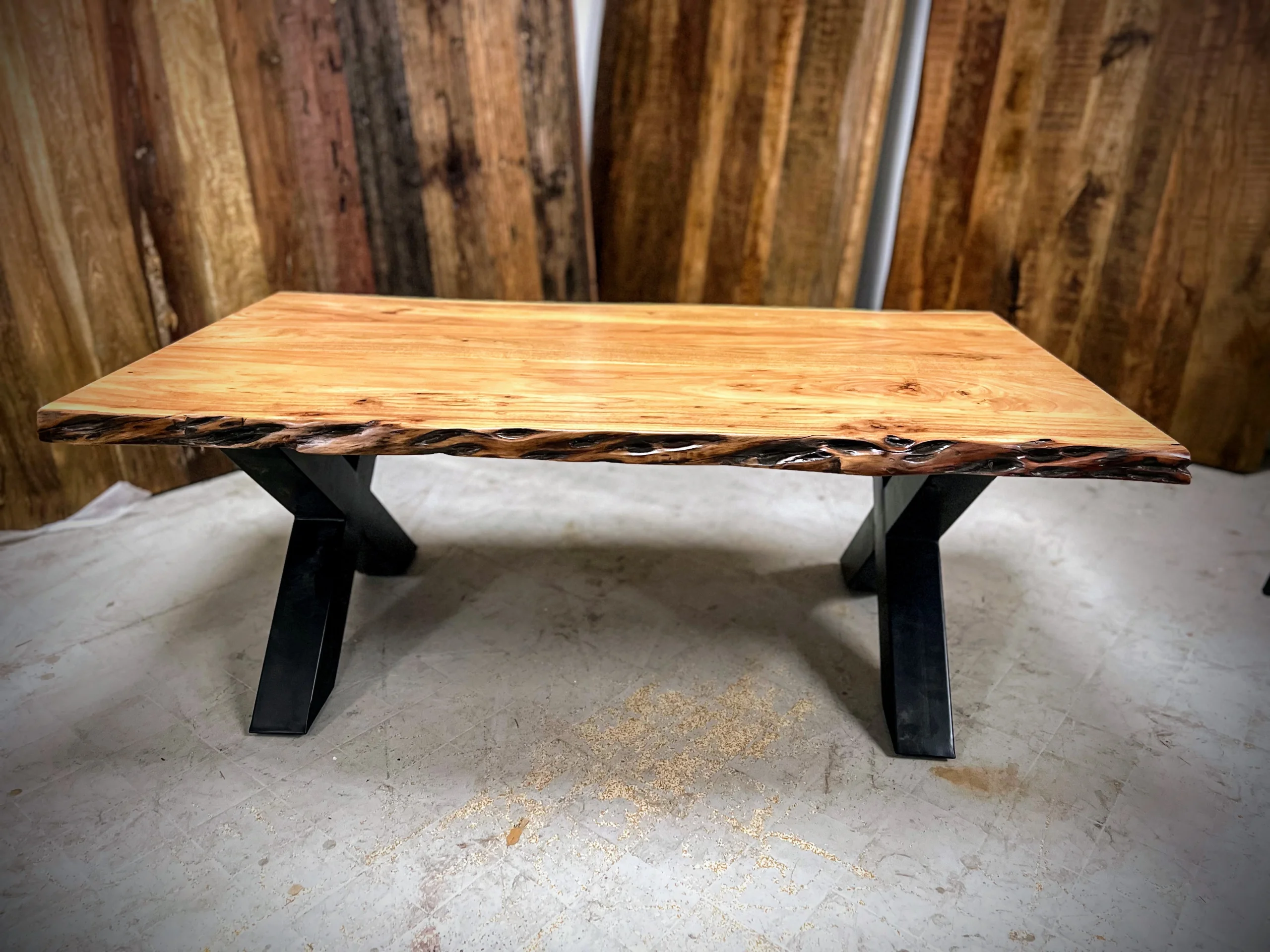 Une table basse avec des pieds métalliques croisés