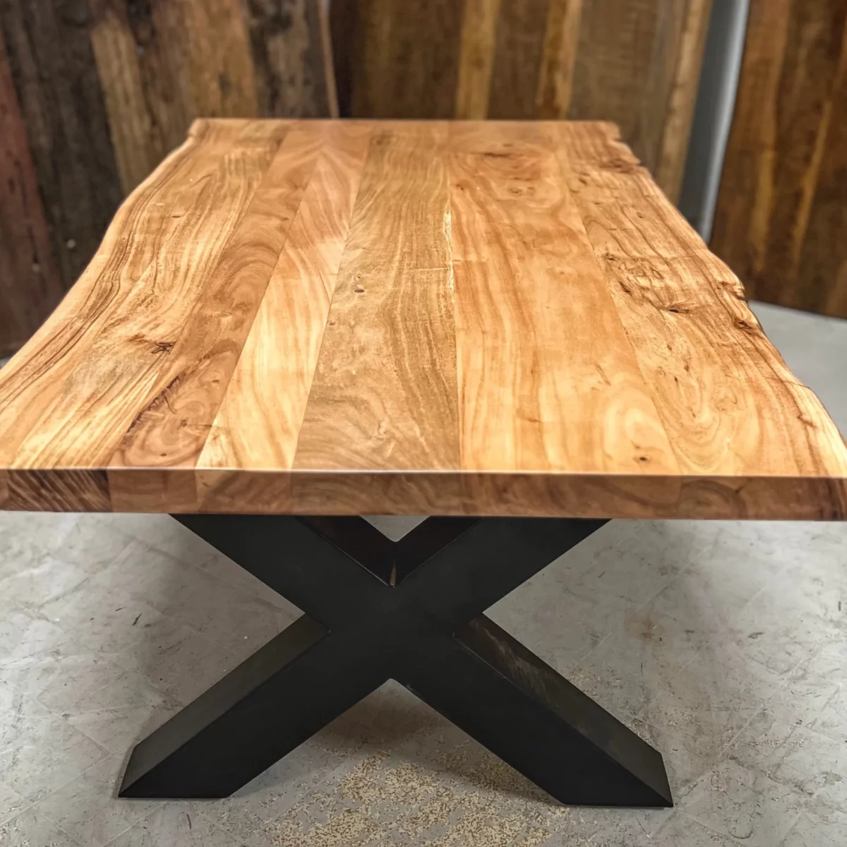 Une table basse avec des pieds en acier en forme de X, symbole de décoration intérieure artisanale