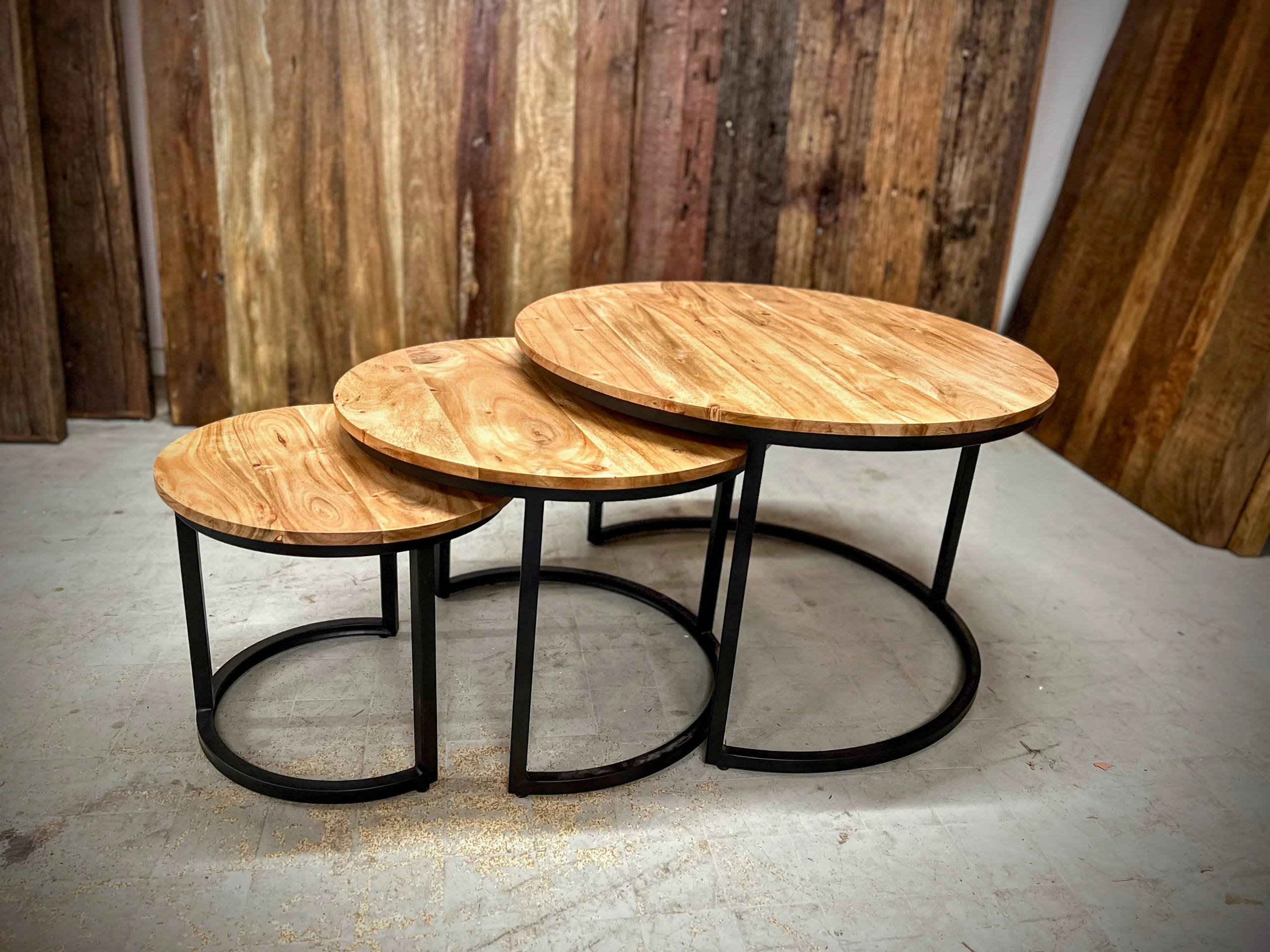 Three round nesting coffee tables in acacia and black steel