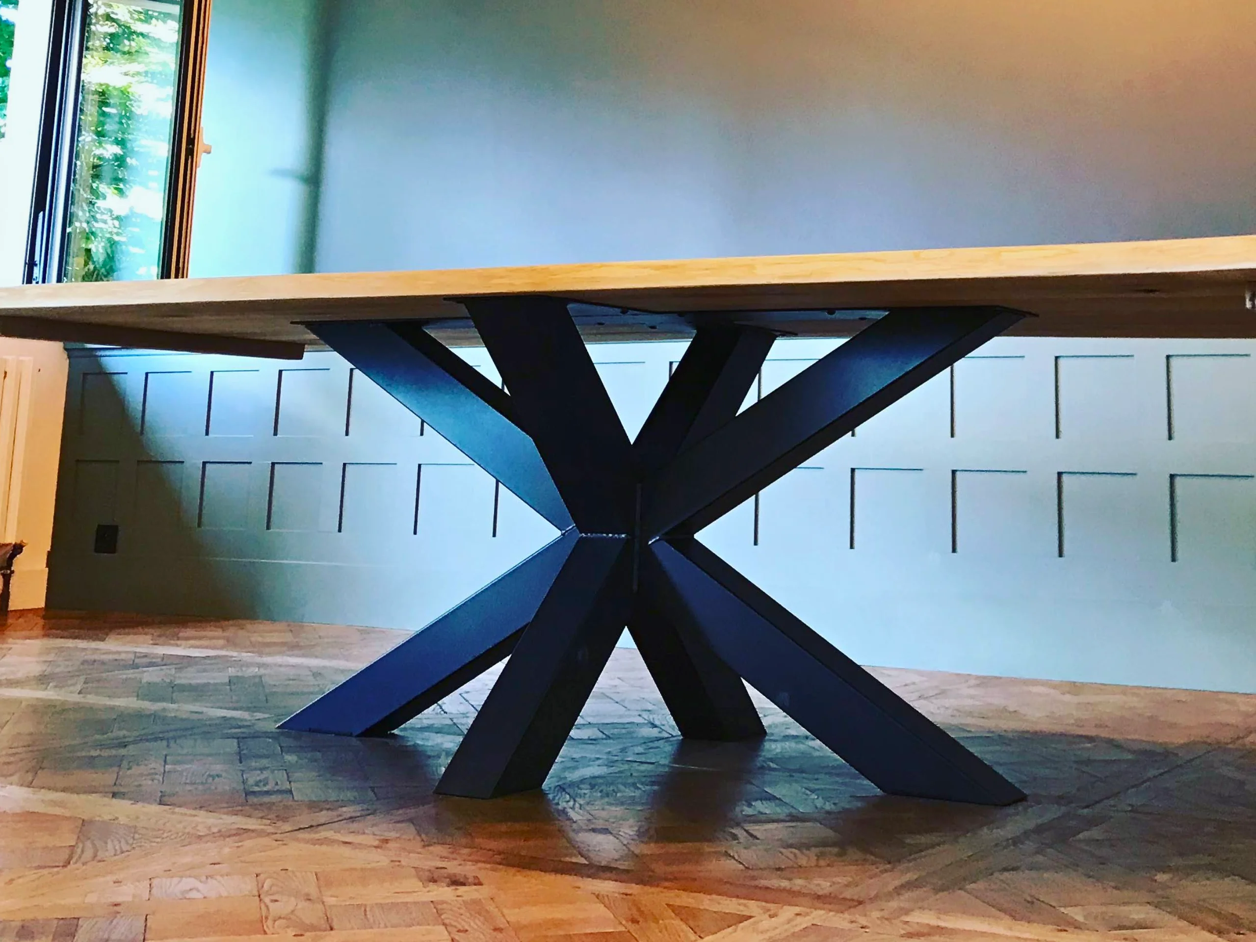 A large dining table with a black metal leg
