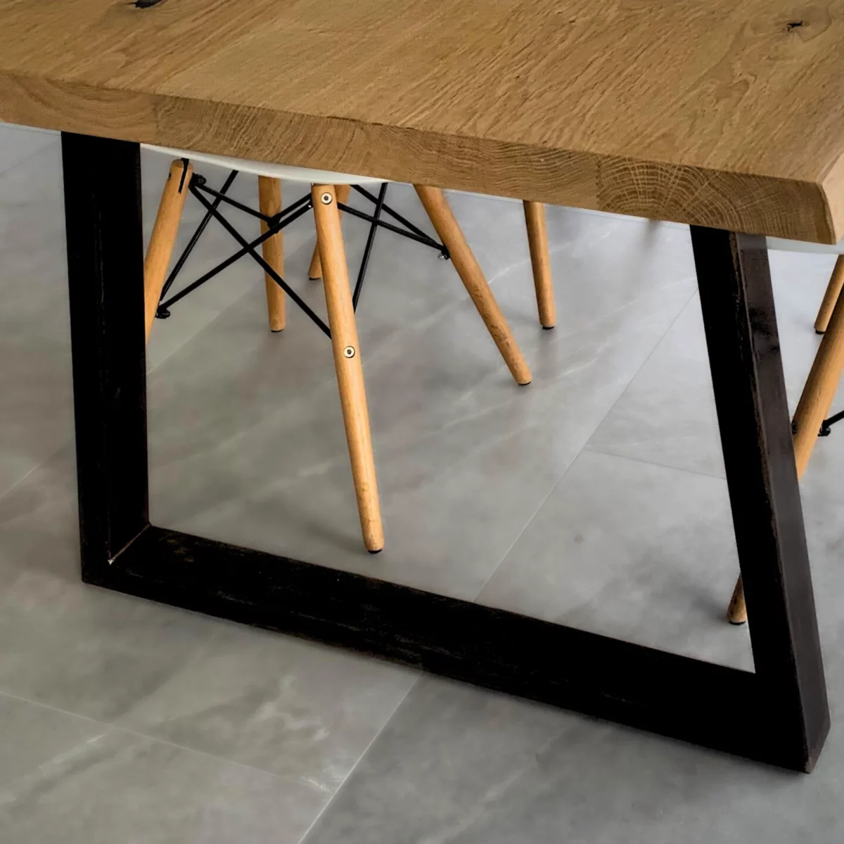 A black steel trapezoid-shaped table leg