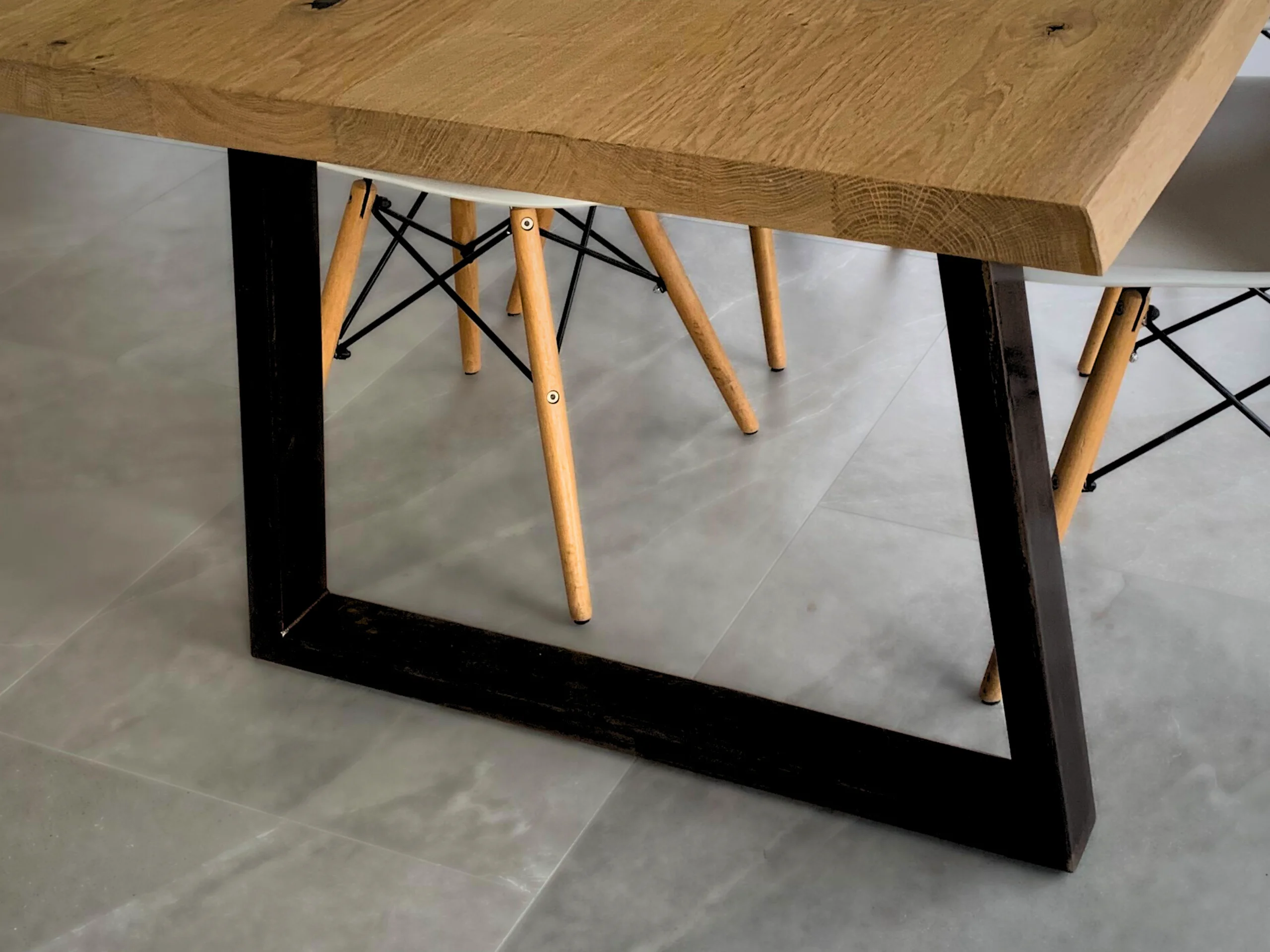 Un pied de table en acier noir, en forme de trapèze