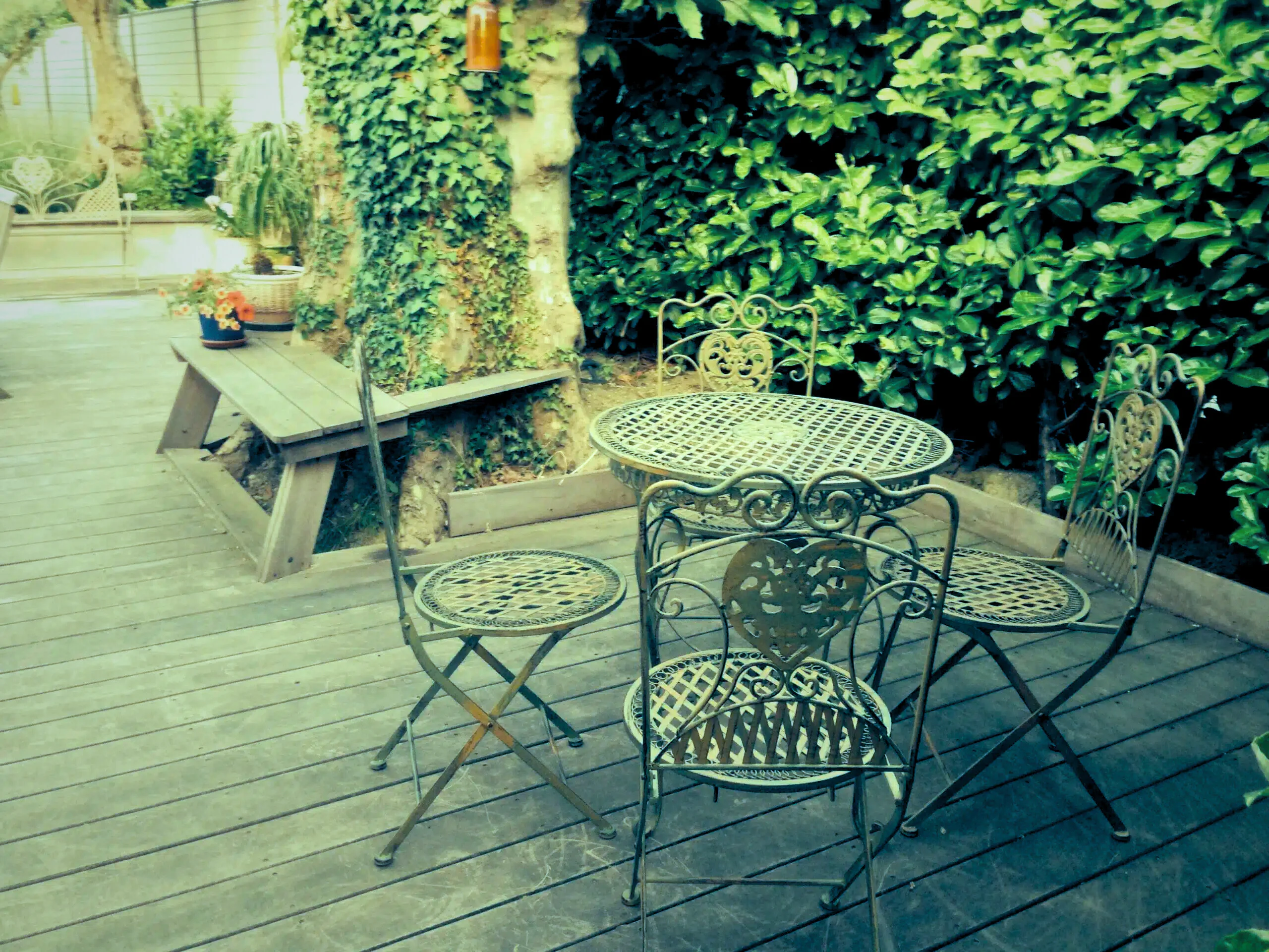 A wrought iron garden lounge set on a patio