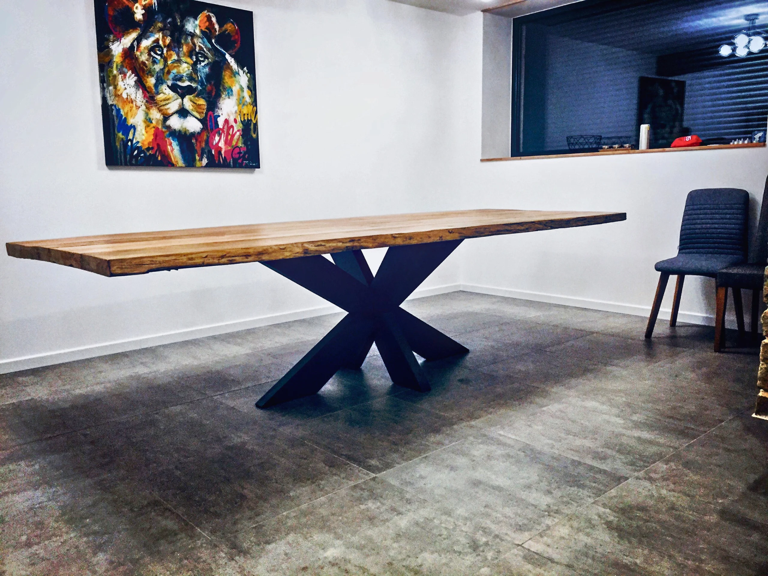 Un grand salon avec un tableau de lion et une grande table dotée d'un pied de table Étoile massif