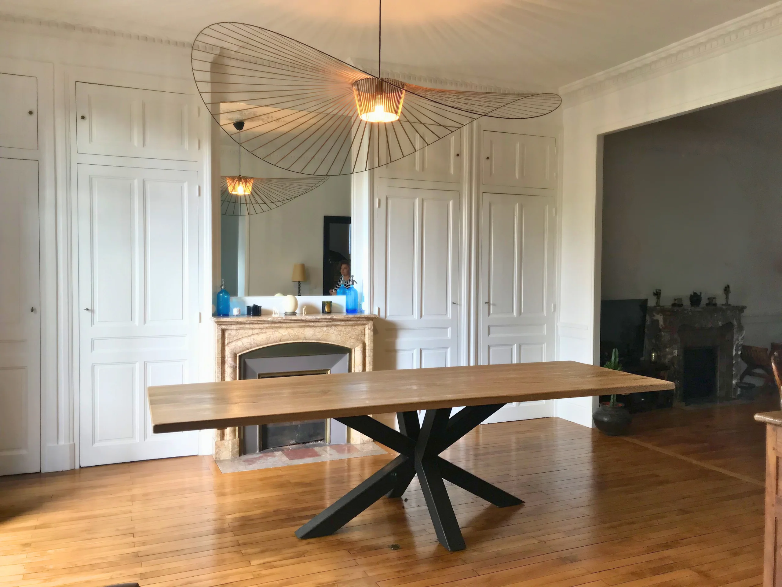 Un salon avec en son centre une table dotée d'un pied central de table acier robuste