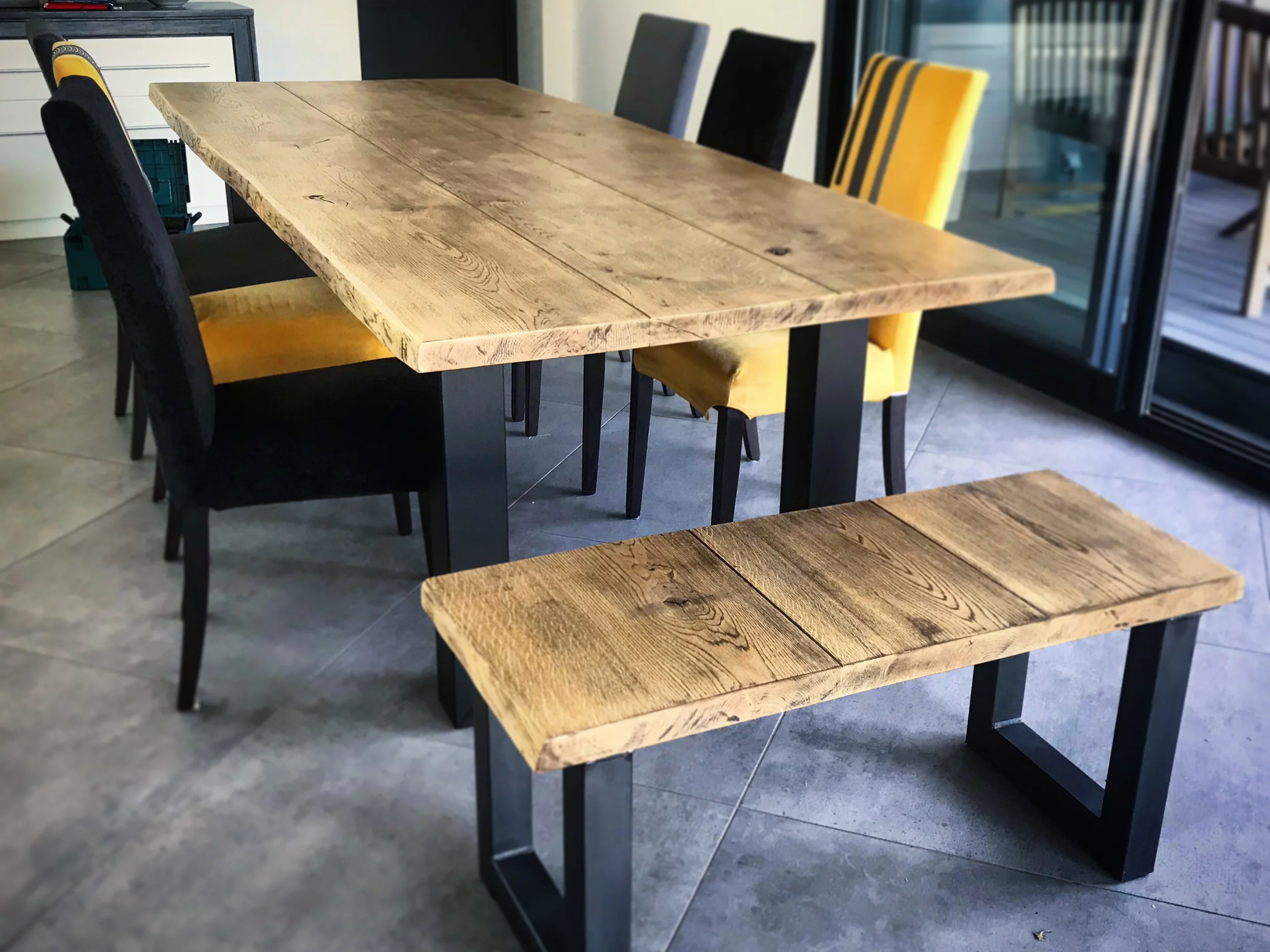 Une table à manger avec des pieds U et un banc avec des pieds U