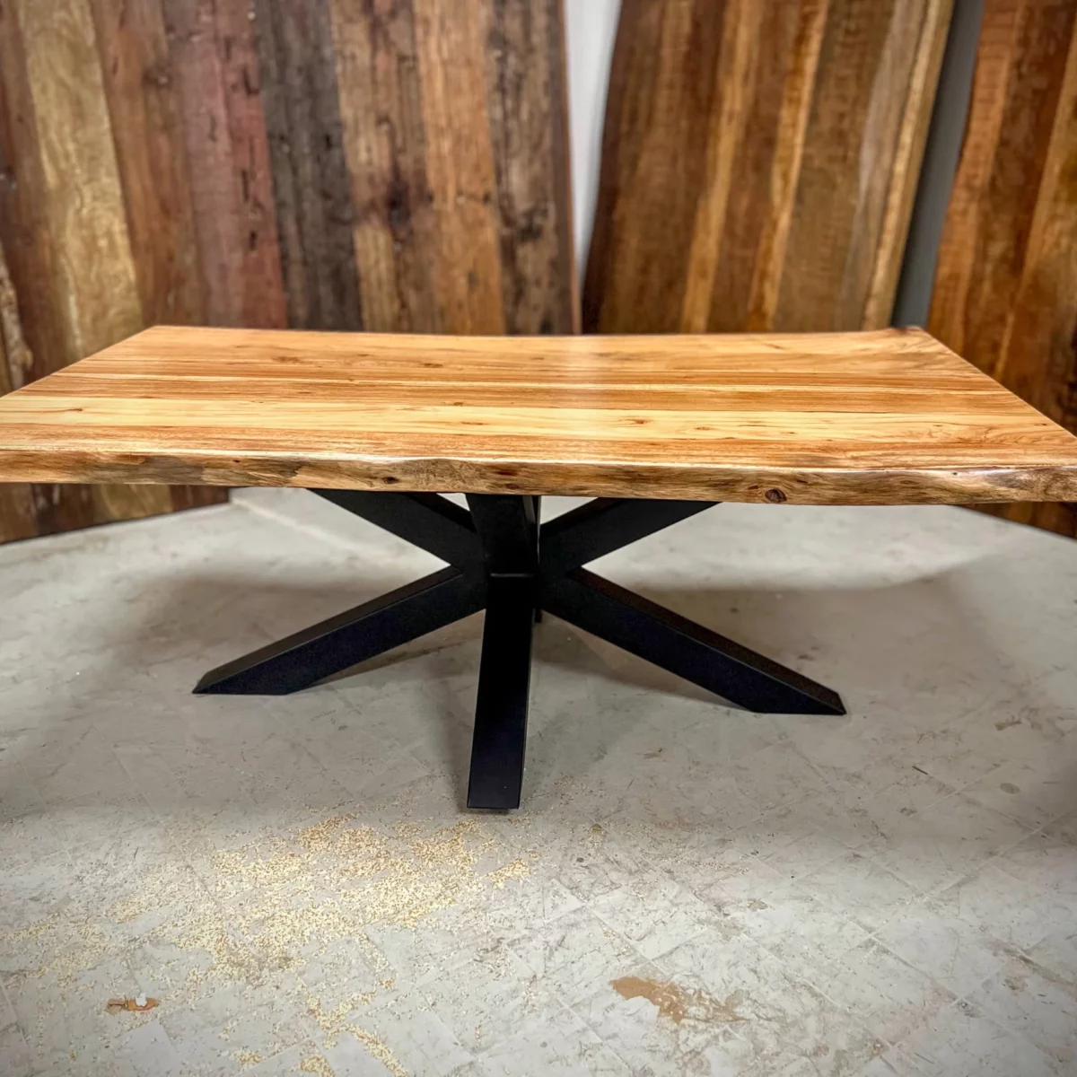 Une table basse avec un pied central en forme d'étoile
