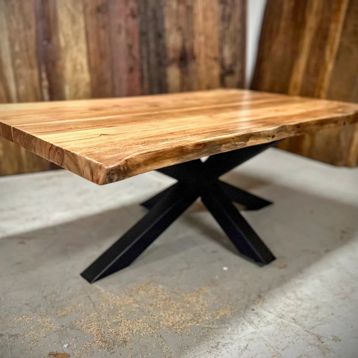 Une table basse avec un pied central dans un atelier de menuiserie