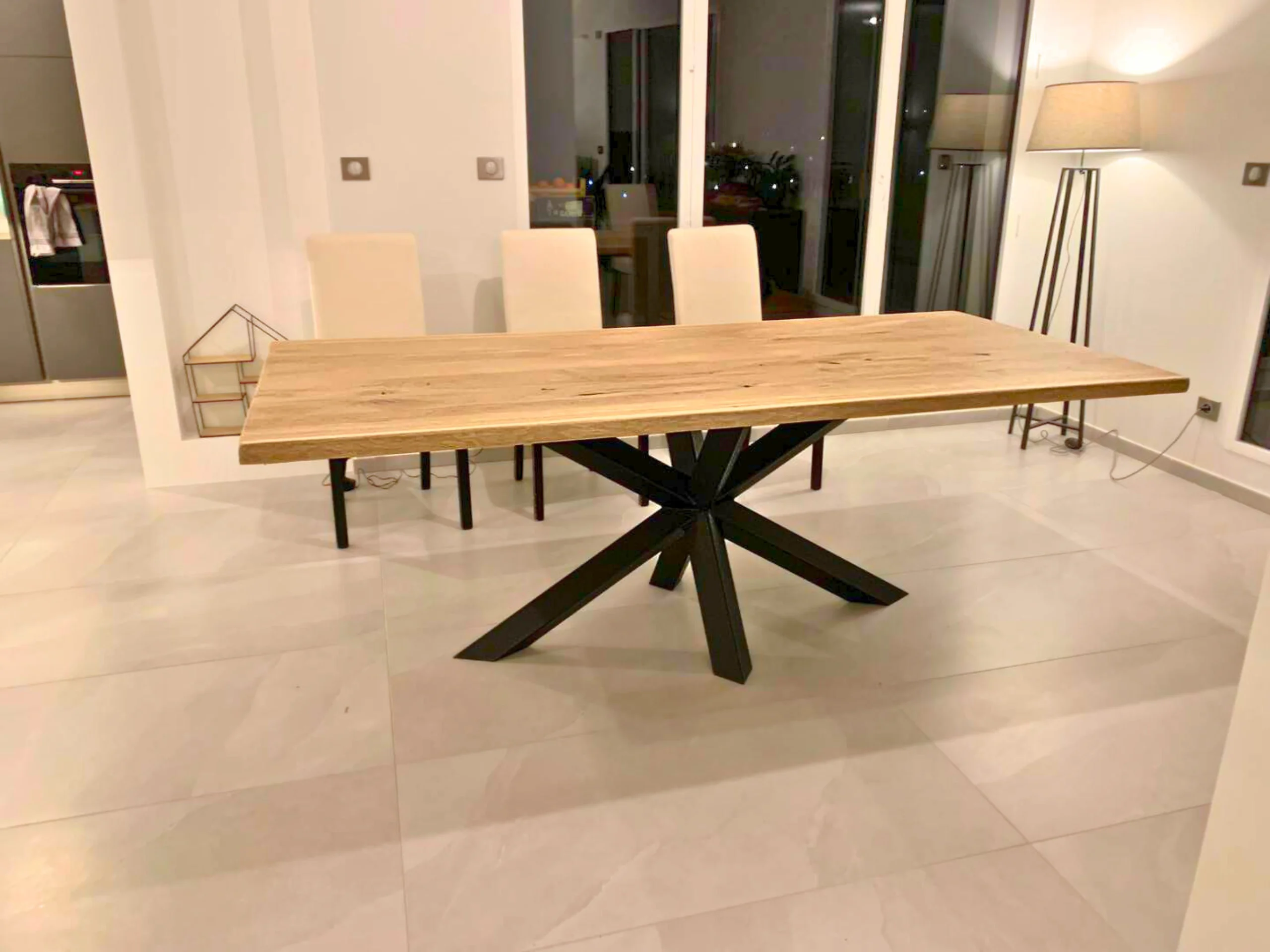 Une table à manger avec un pied central Diamant dans un salon avec un carrelage clair