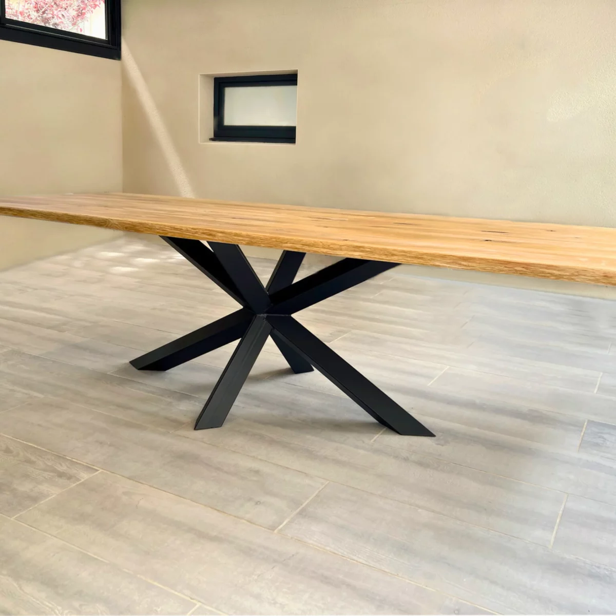 Une table en chêne avec un pied central Diamant en acier noir dans un salon clair