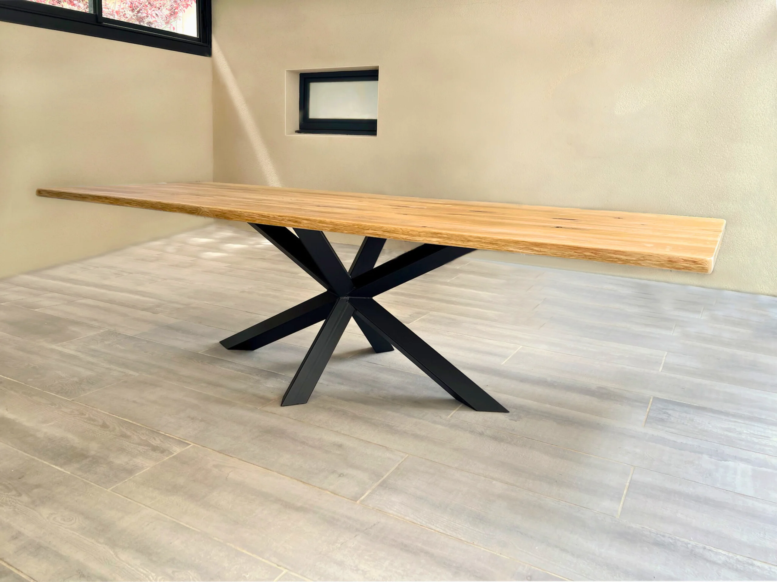 An oak table with a black steel Diamond pedestal base in a bright living room