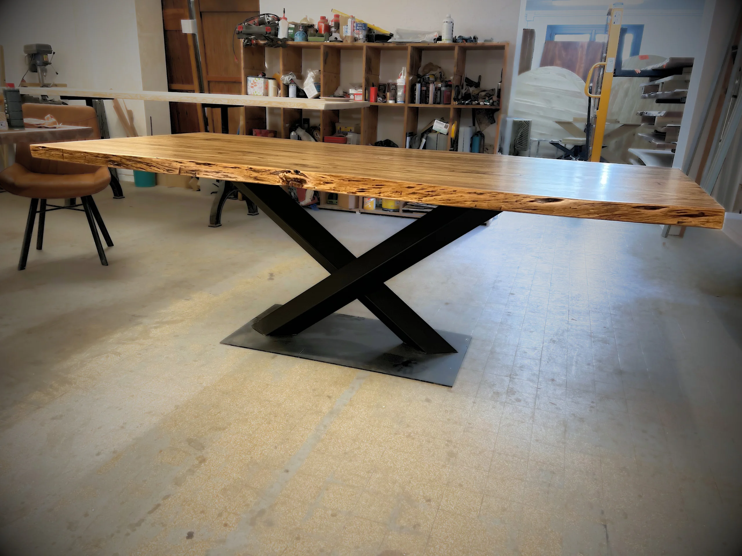 Une table en bois massif avec un pied central en acier